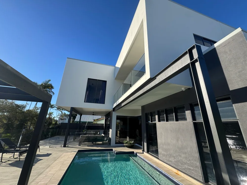 White and charcoal house beside a swimming pool